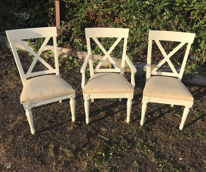 Cream-painted chairs waiting for delivery
